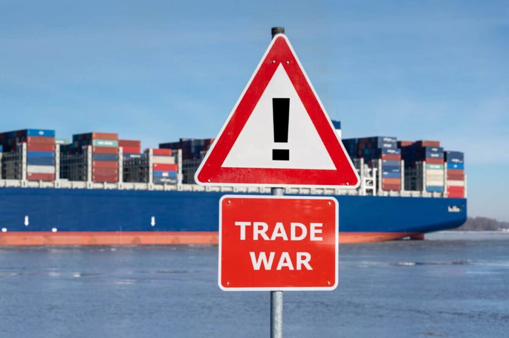 Warning sign with the text "Trade war" in front of container ship